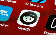 The Reddit logo as an app on a phone screen.